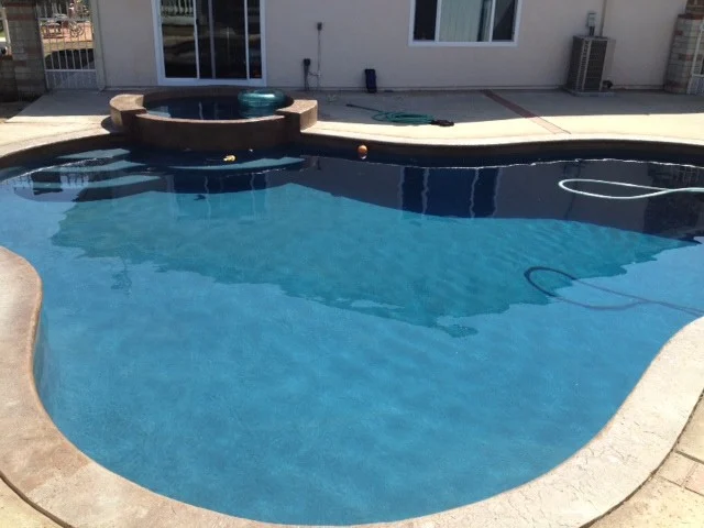 Pool with a raised spa beside the house