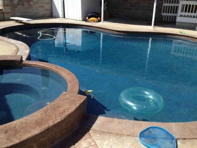 Pool with an attached spa and a diving board