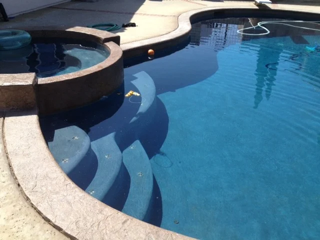 Pool steps beside an attached spa