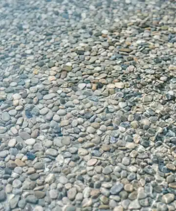 PebbleTec aggregate pool surface with visible stone texture and blue-green water tone